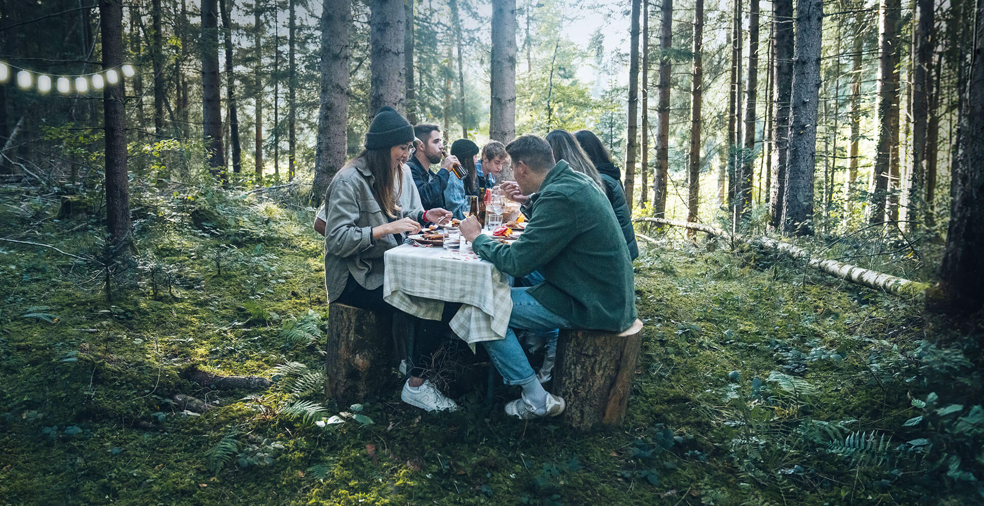 Gruppe von Menschen im Wald mit veganen Burgern